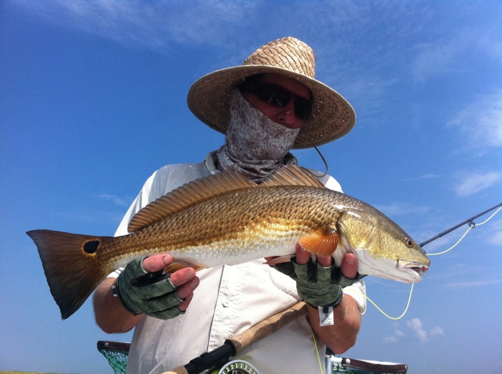 Man inspects the redfish he just captured