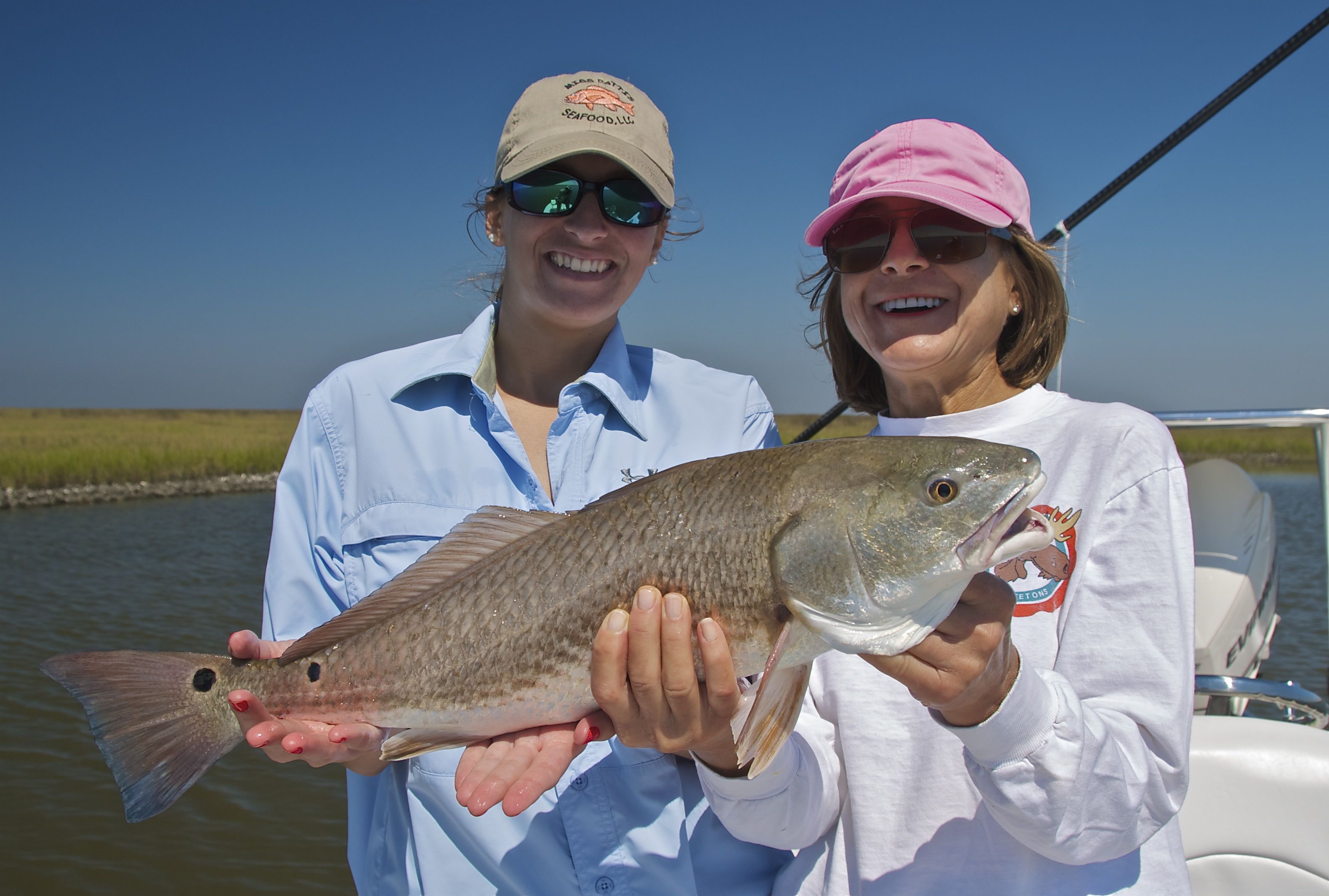 Two women are delighted after catching a redfish