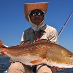 Man in cowboy hat with his freshly caught redfish
