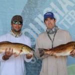 Men displaying the redfish that they caught
