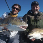 Two men are delighted after a successful fishing trip