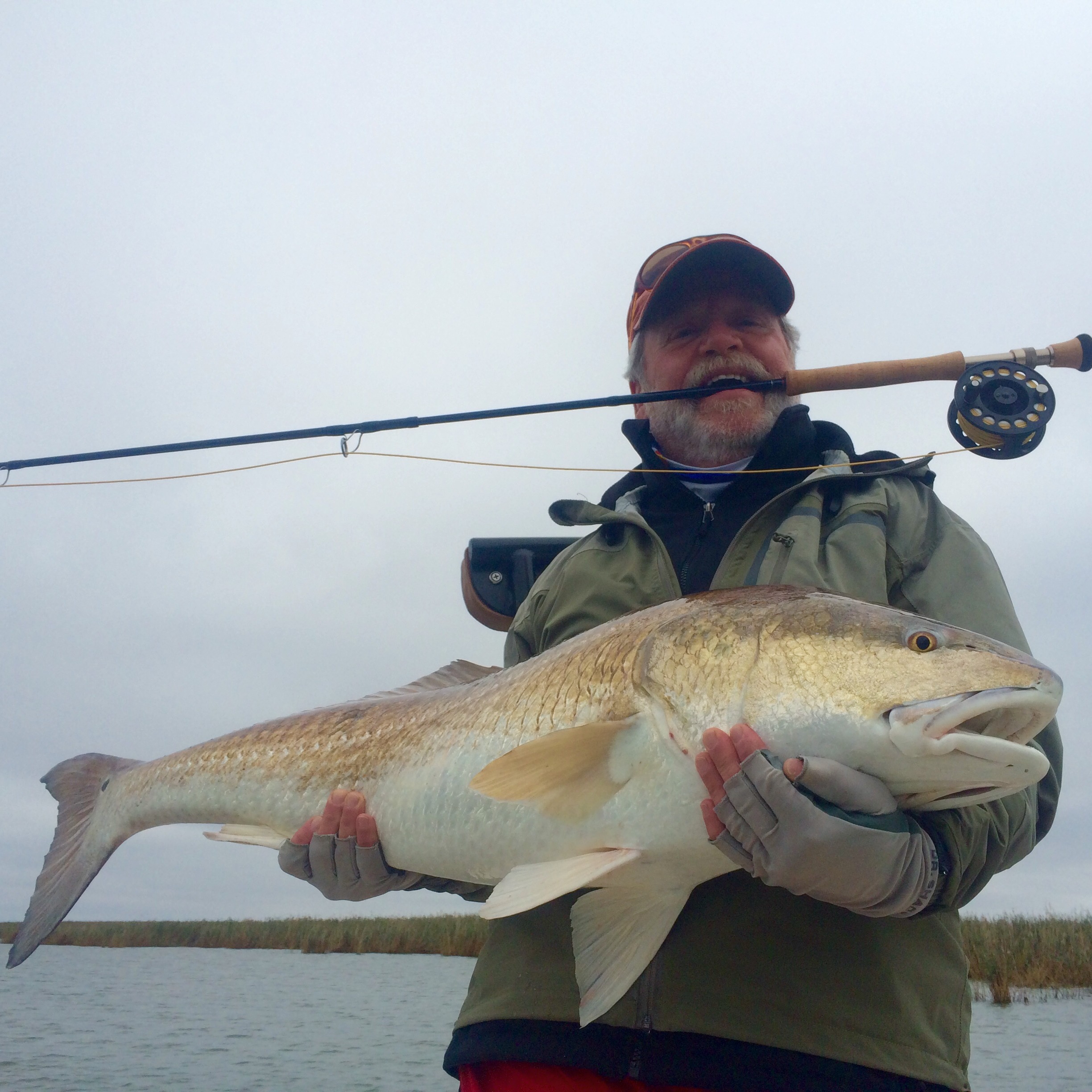Man smiles after catching a Jumbo Louisiana Redfish