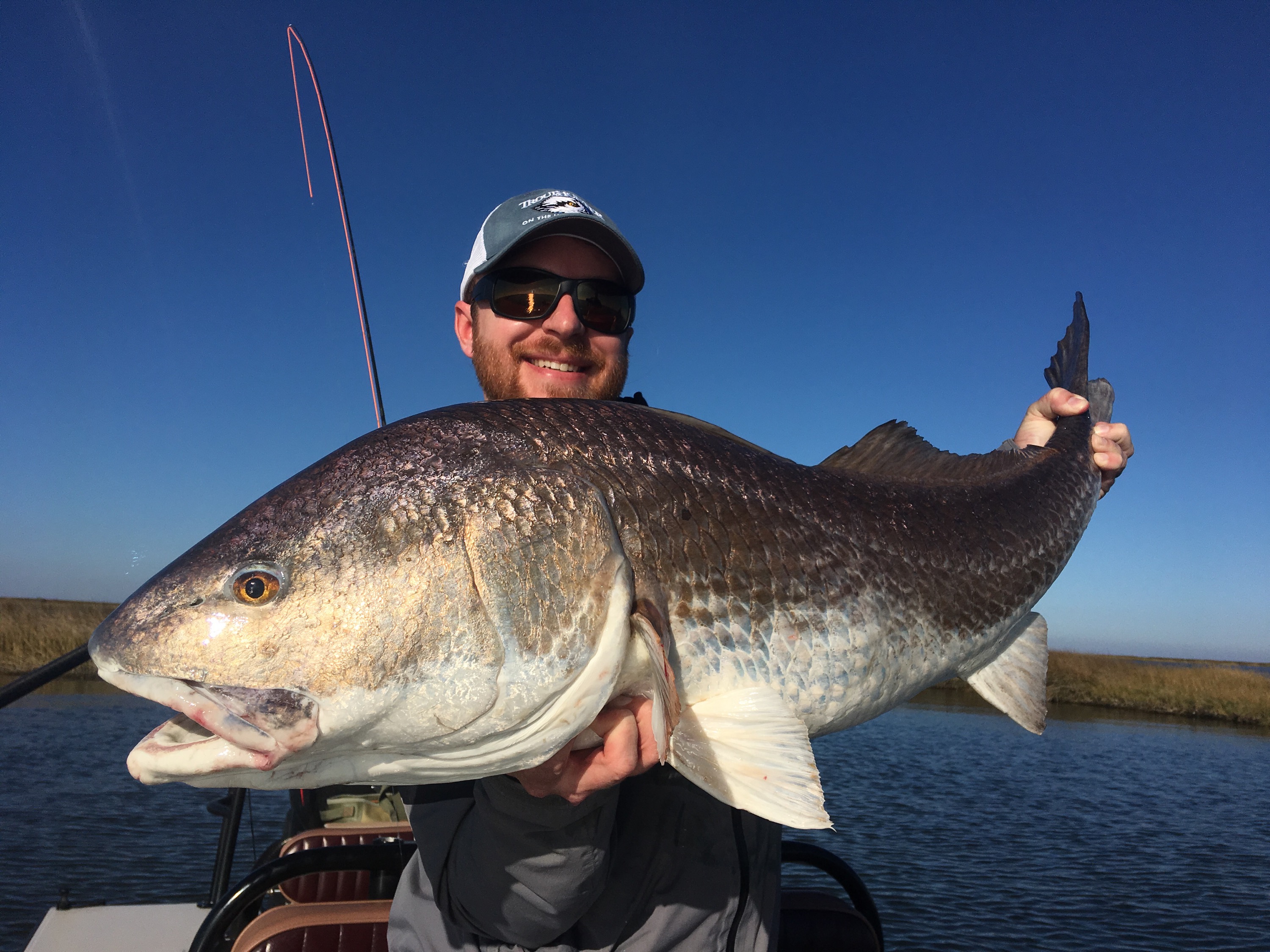 Man smiles with a huge fish captured during a trip