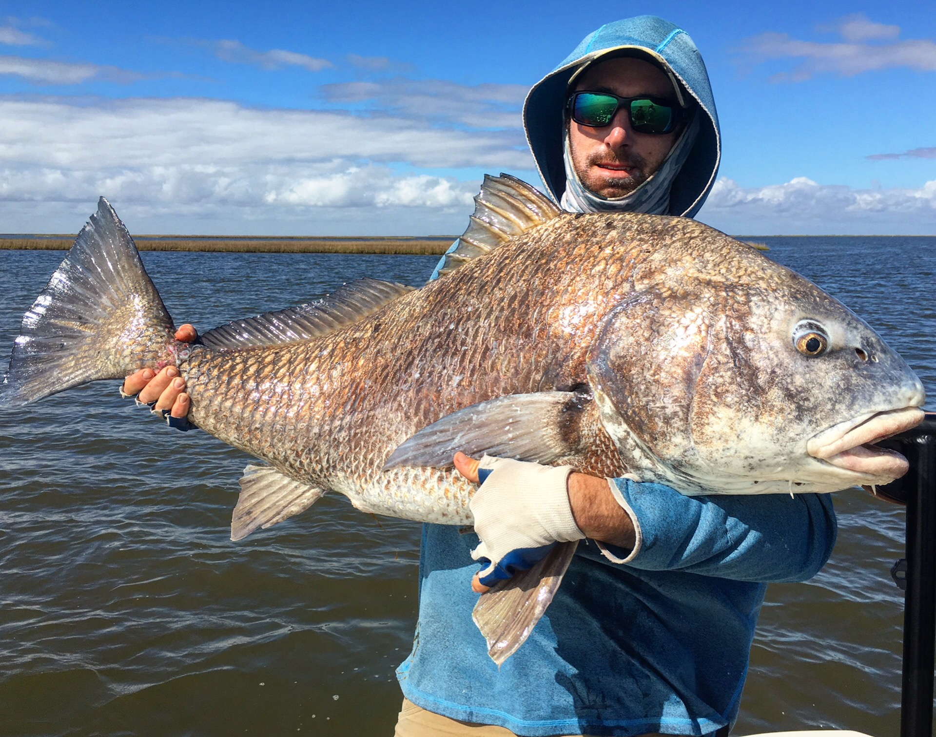 Man displays a huge fish captured during a trip