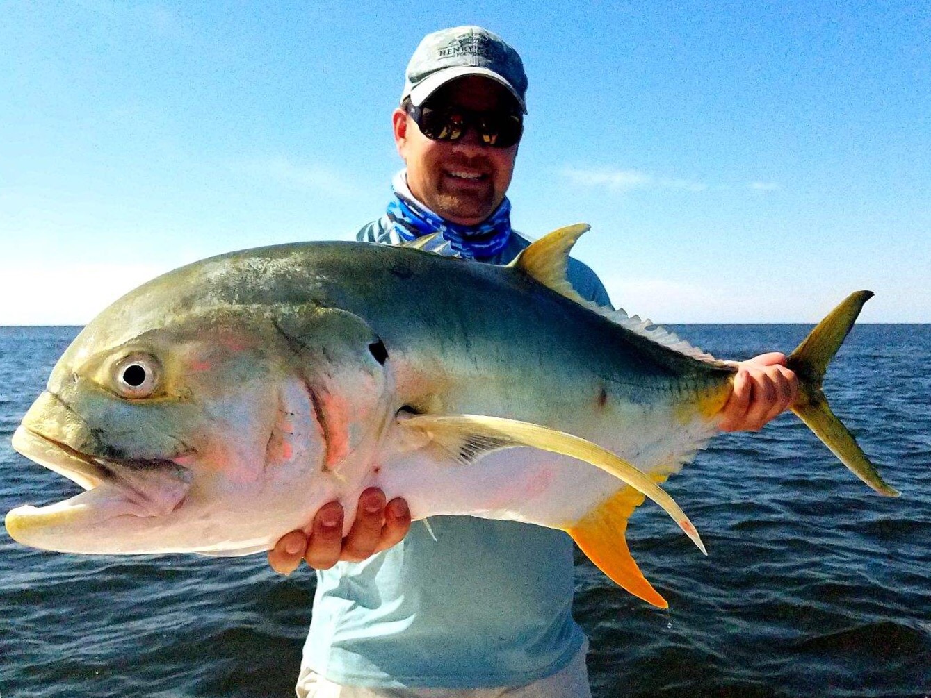 Man with a large fish during summer fishing trip