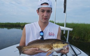 A young fisherman poses with the fish he caught