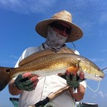 Man inspects the redfish he just captured