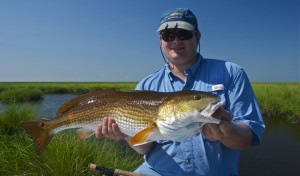 Man proudly displays the fish he just caught