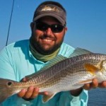 Man in light blue T Shirt showing the fish he caught