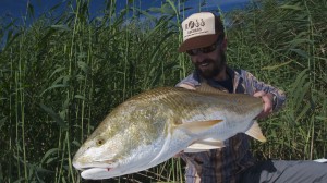 Man proudly looks at the fish he just caught