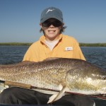 Young boy delightfully poses with his catch