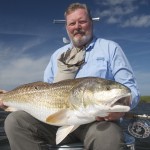 Bearded man in blue shirt with the fish he caught