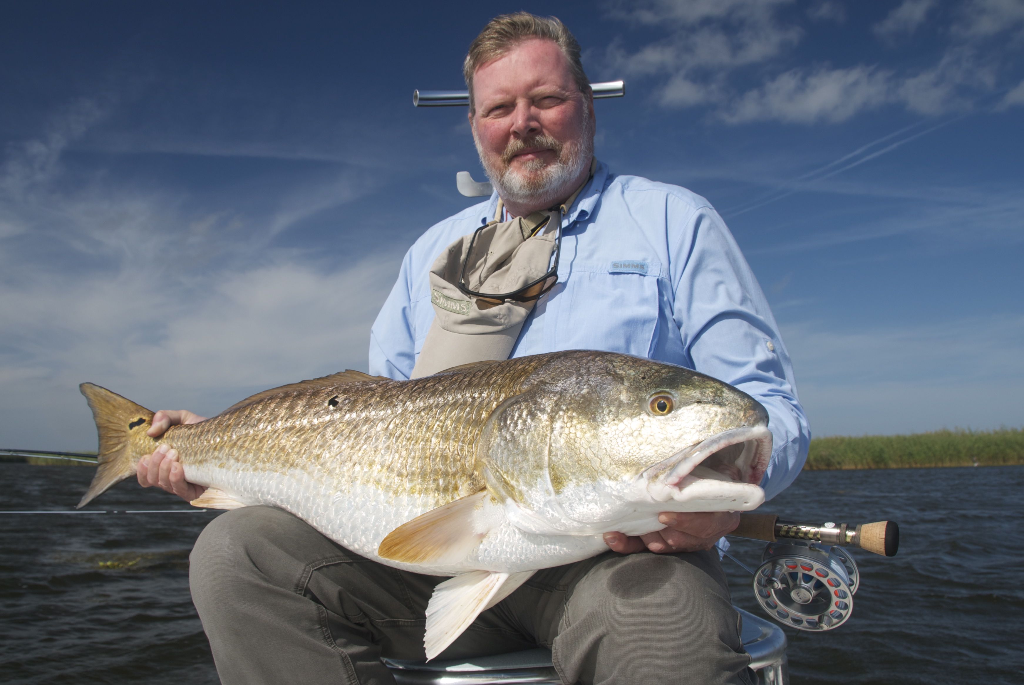 Bearded man in blue shirt with the fish he caught