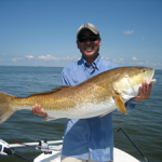 Man smiles at the cameras with his fresh catch