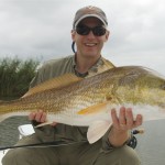 Man smiling posing with the fish he just caught