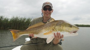 Man smiling posing with the fish he just caught