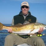 Man in green jacket with the fish he just caught