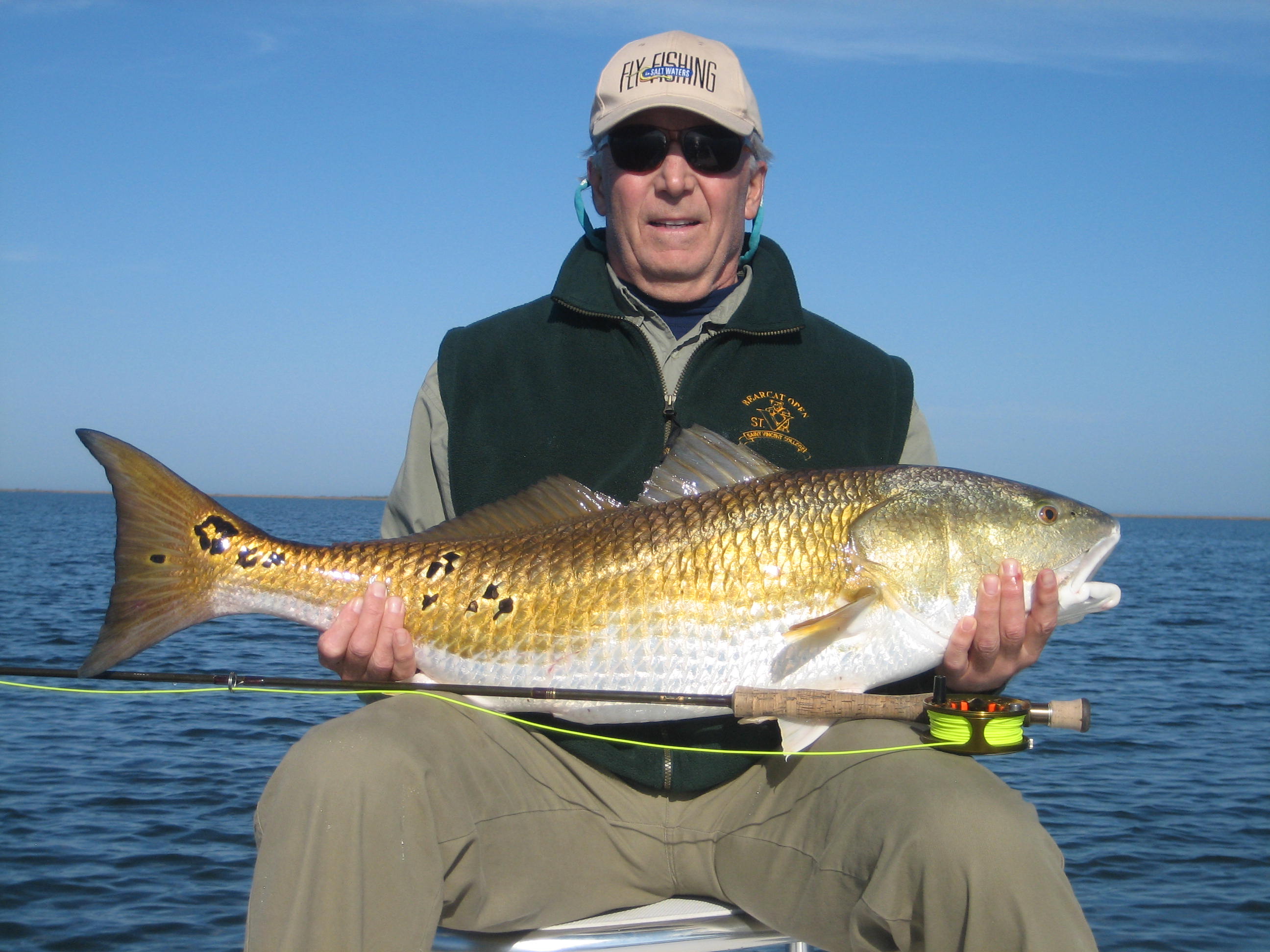 Man in green jacket with the fish he just caught