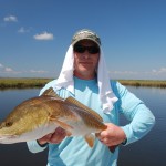 Man in blue jacket poses with the large fish he caught