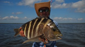 Man in cowboy hat displays the fish he caught