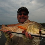 Man displays the large redfish he just caught