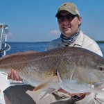 Man proudly displays the large fish he caught