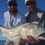 Two men are happy with the fish they just caught