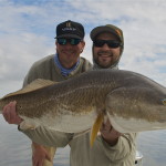 Two men delightfully pose with the fish they caught