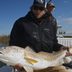 Man in jacket shows the fish he just caught