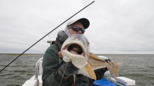 An old man poses with the fish he caught