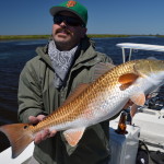 Man in grey outfit with the redfish he caught