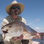 Man with cigarette posing with his catch