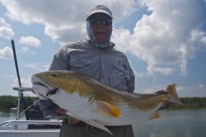 Man in grey hoodie posing with his catch