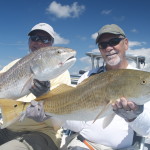 Two men are all smiles posing with their catch