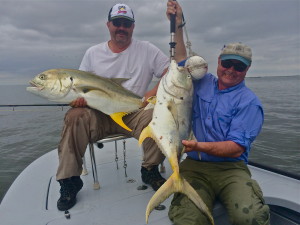 Two men displaying the fish they just caught