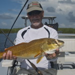 Man in white shirt showing off his redfish