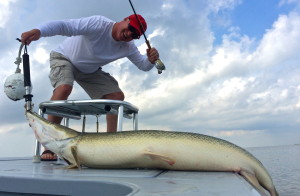 Man strikes a fun pose after catching a fish