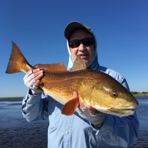 Man in fishing outfit displays his capture