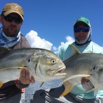 Two men posing with the large fishes they caught