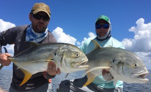 Two men posing with the large fishes they caught