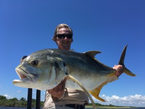 Man smilingly displays the large fish he has caught