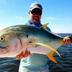 Man with a large fish during summer fishing trip