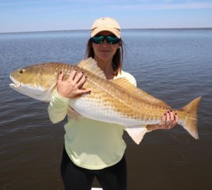 Lady displays her capture during a spring fishing trip