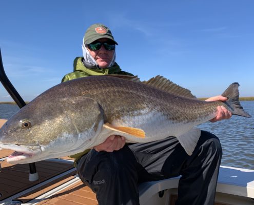 Man rests on the boat with a large fish he caught