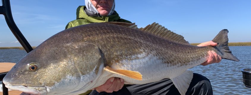 Man rests on the boat with a large fish he caught