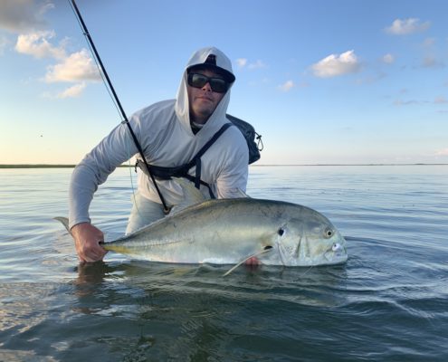 Man lifting up a large fish from the water